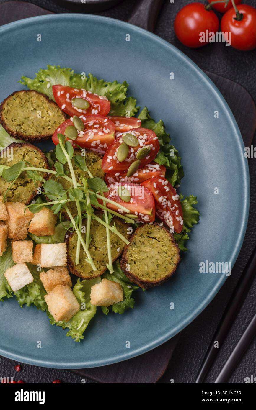 Essen, deftige köstliche frittierte Falafel aus Kichererbsen, Kümmel, Hummus mit Salz und Gewürzen auf dunklem Betonhintergrund Stockfoto