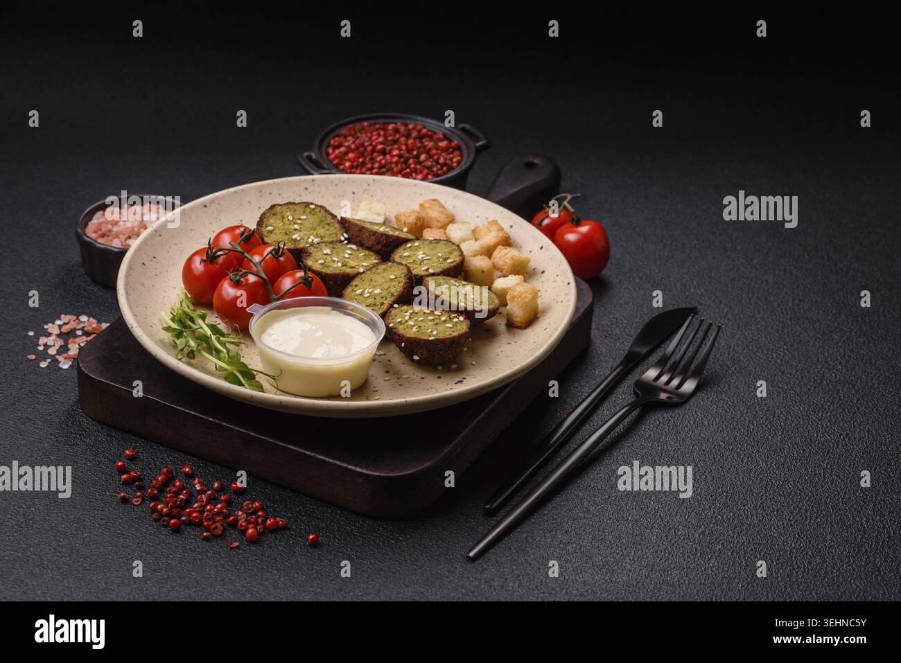 Essen, deftige köstliche frittierte Falafel aus Kichererbsen, Kümmel, Hummus mit Salz und Gewürzen auf dunklem Betonhintergrund Stockfoto