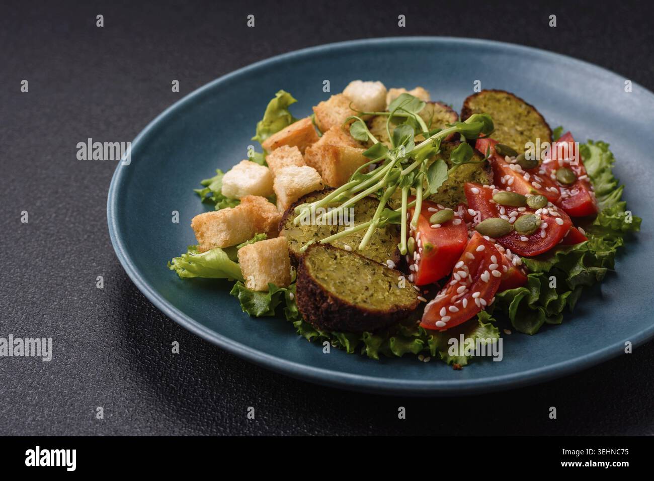 Essen, deftige köstliche frittierte Falafel aus Kichererbsen, Kümmel, Hummus mit Salz und Gewürzen auf dunklem Betonhintergrund Stockfoto