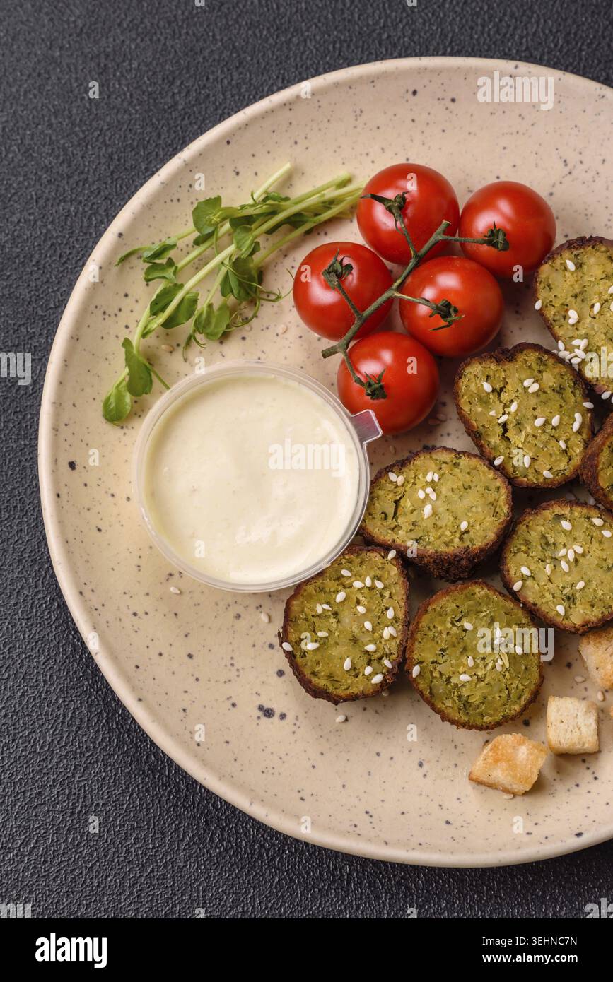 Essen, deftige köstliche frittierte Falafel aus Kichererbsen, Kümmel, Hummus mit Salz und Gewürzen auf dunklem Betonhintergrund Stockfoto