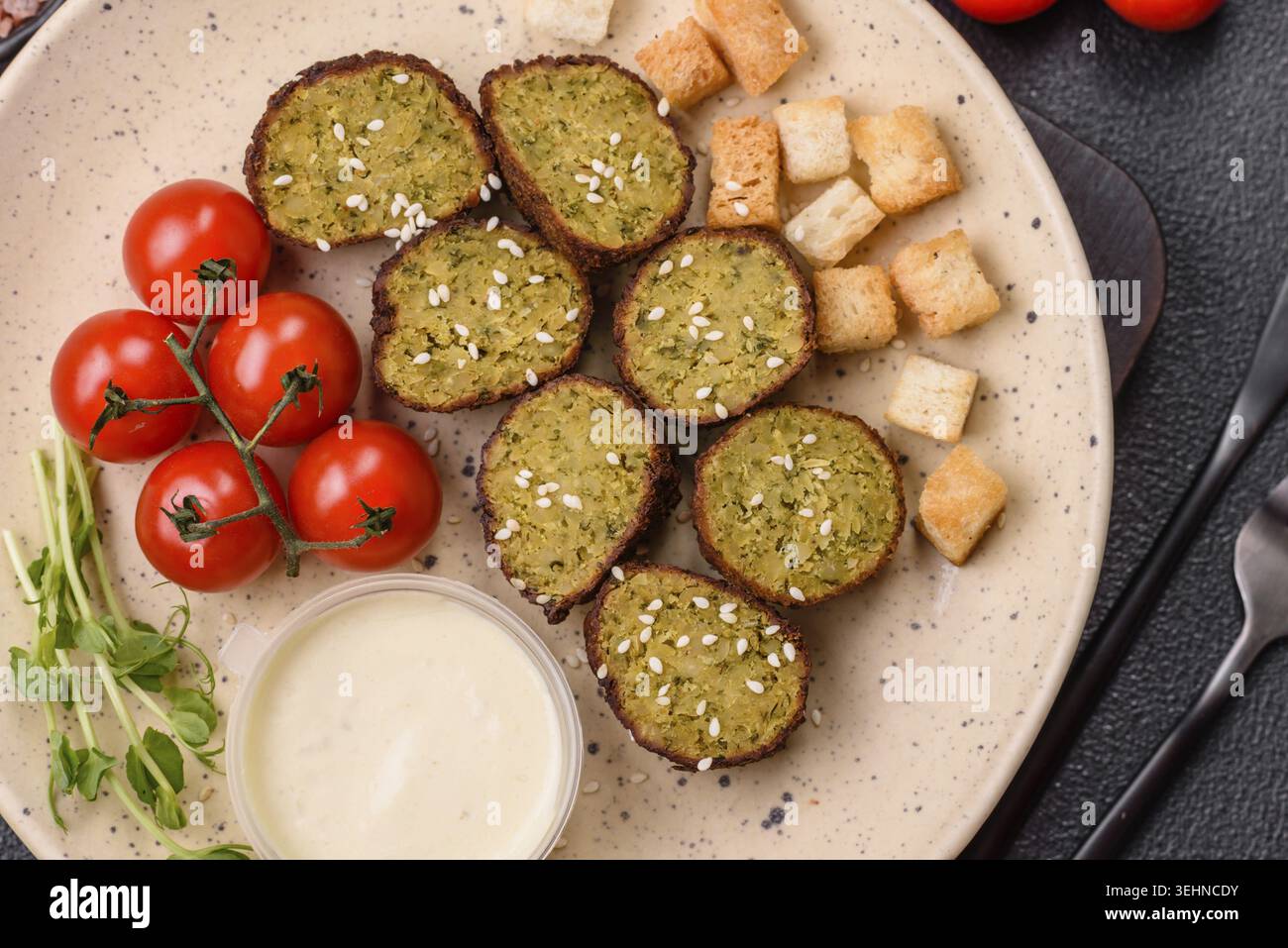 Essen, deftige köstliche frittierte Falafel aus Kichererbsen, Kümmel, Hummus mit Salz und Gewürzen auf dunklem Betonhintergrund Stockfoto