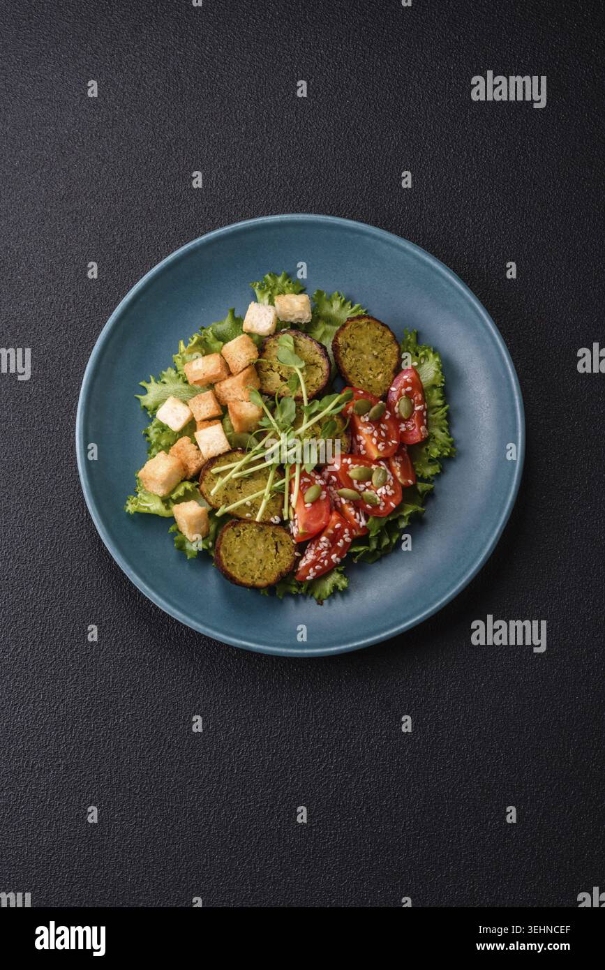 Essen, deftige köstliche frittierte Falafel aus Kichererbsen, Kümmel, Hummus mit Salz und Gewürzen auf dunklem Betonhintergrund Stockfoto