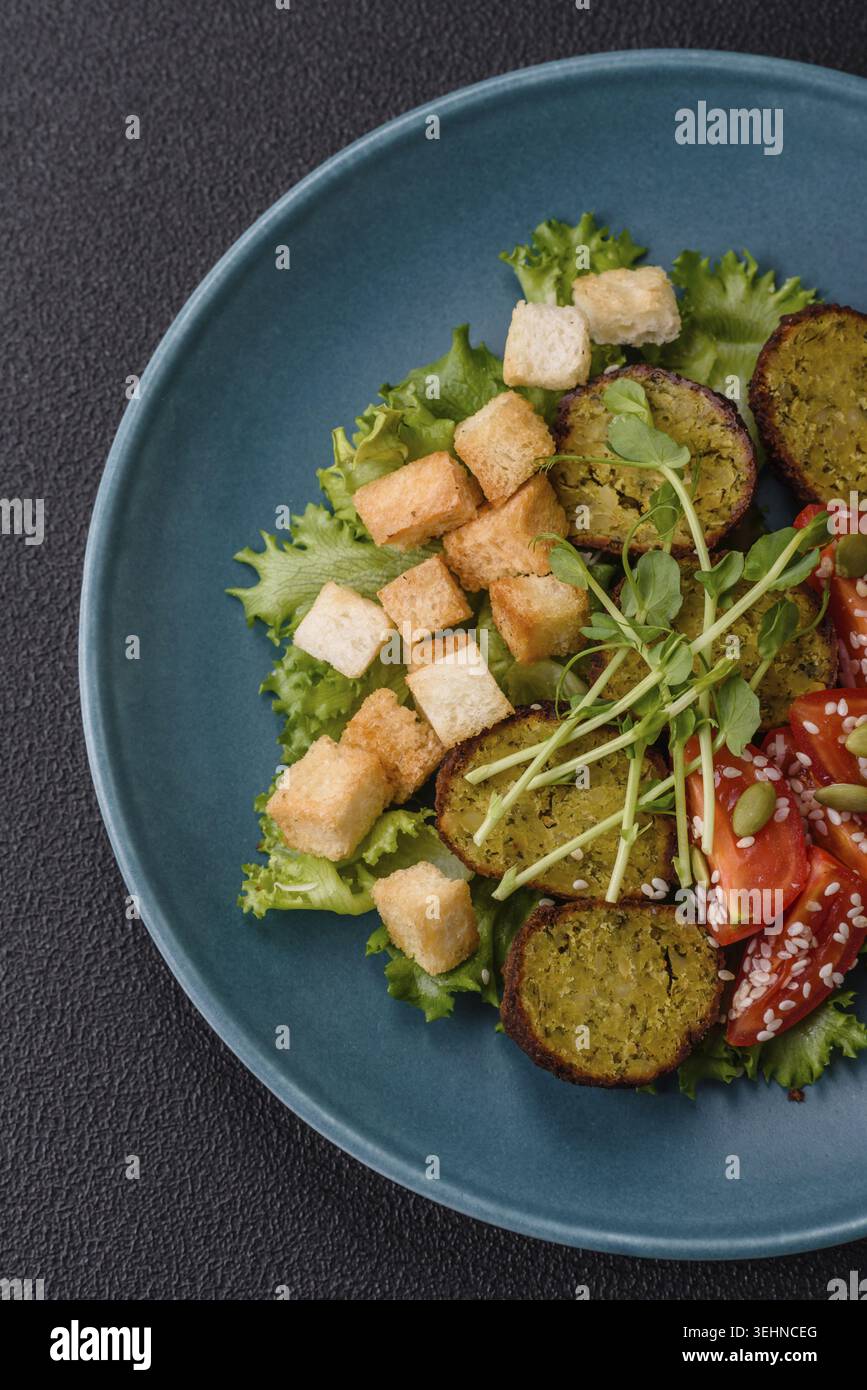 Essen, deftige köstliche frittierte Falafel aus Kichererbsen, Kümmel, Hummus mit Salz und Gewürzen auf dunklem Betonhintergrund Stockfoto