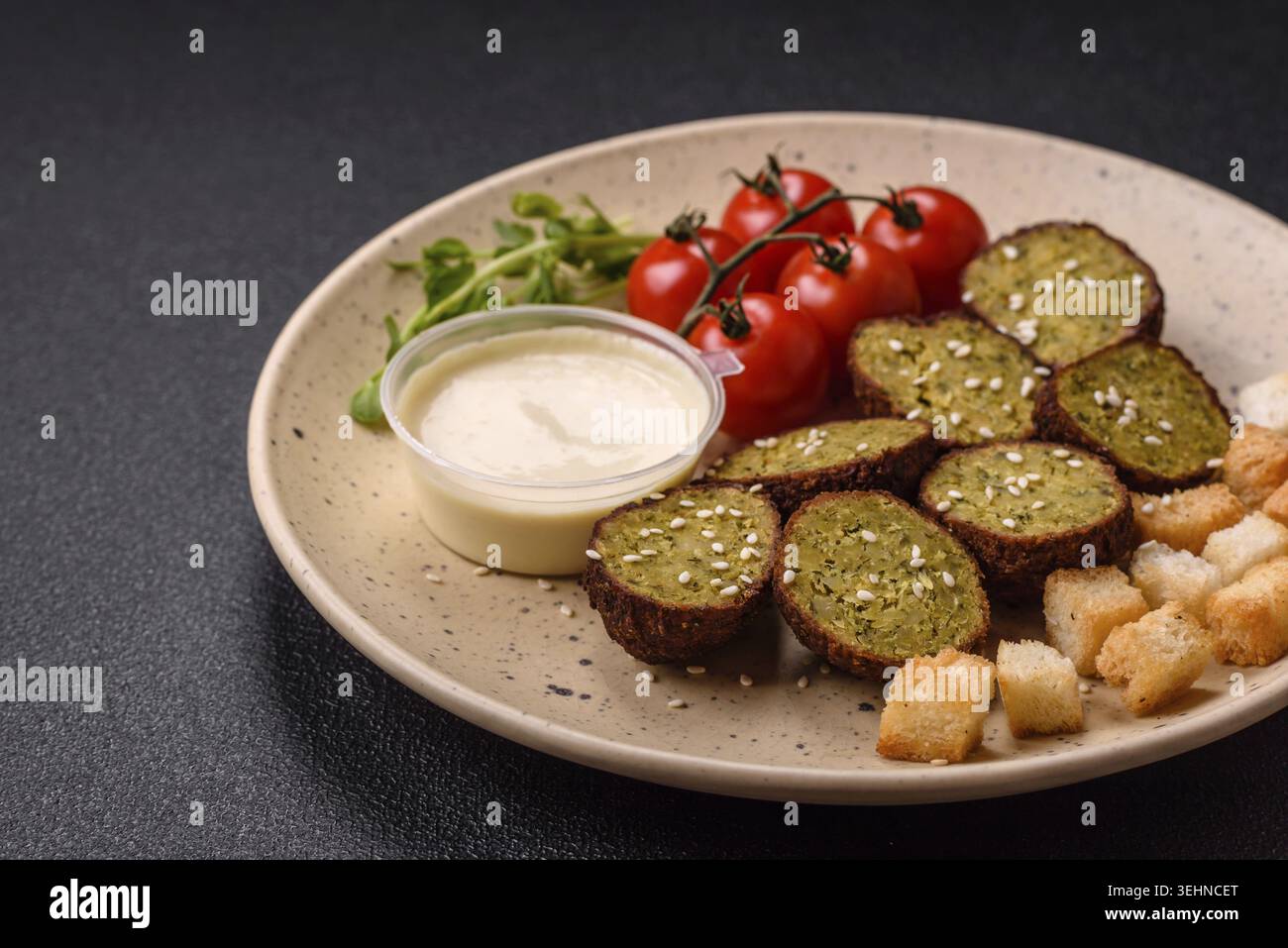 Essen, deftige köstliche frittierte Falafel aus Kichererbsen, Kümmel, Hummus mit Salz und Gewürzen auf dunklem Betonhintergrund Stockfoto