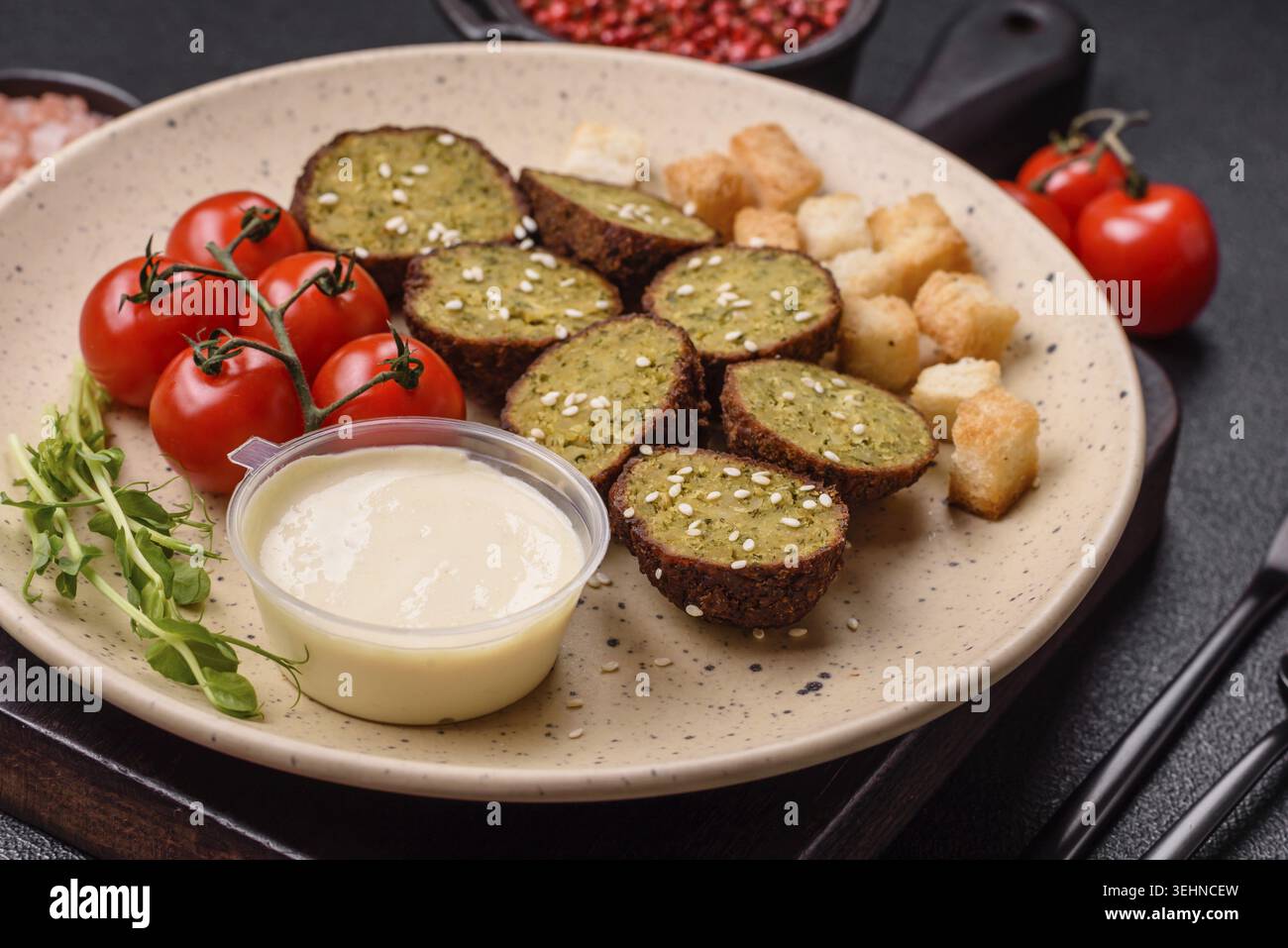 Essen, deftige köstliche frittierte Falafel aus Kichererbsen, Kümmel, Hummus mit Salz und Gewürzen auf dunklem Betonhintergrund Stockfoto