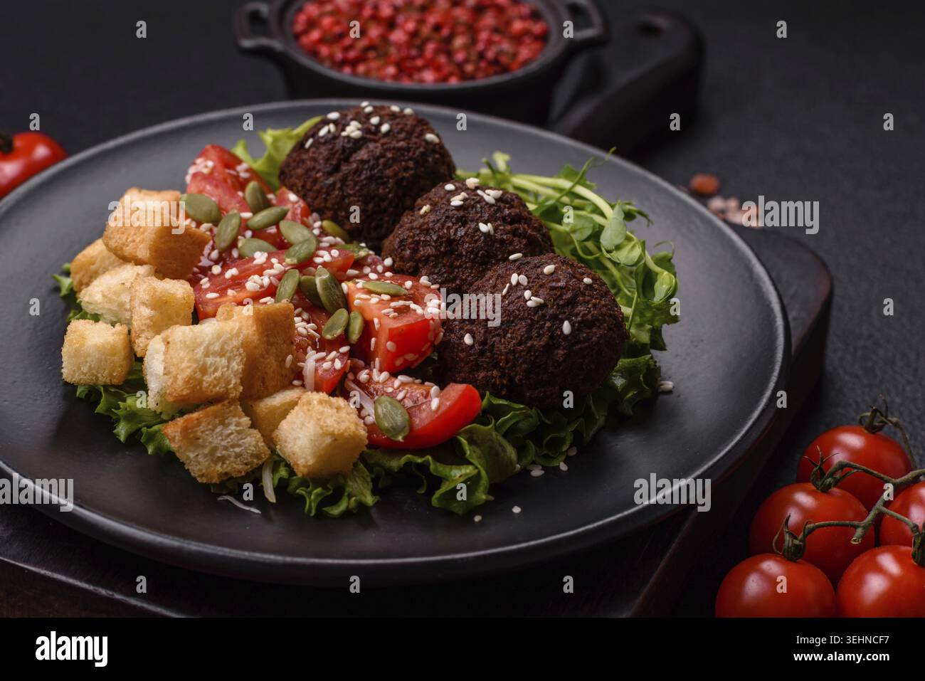 Essen, deftige köstliche frittierte Falafel aus Kichererbsen, Kümmel, Hummus mit Salz und Gewürzen auf dunklem Betonhintergrund Stockfoto