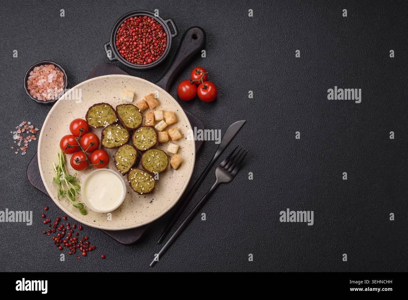 Essen, deftige köstliche frittierte Falafel aus Kichererbsen, Kümmel, Hummus mit Salz und Gewürzen auf dunklem Betonhintergrund Stockfoto