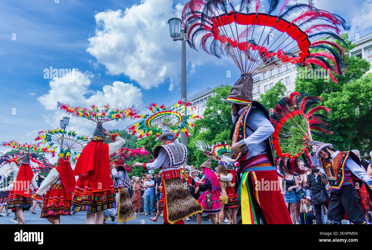 Berlin, Deutschland - 24. Mai 2026: Anden-Folklore-inspirierte Künstler mit kreisförmigen Federkopfschmuck tanzen während des Karnevals der Kulturen. Stockfoto
