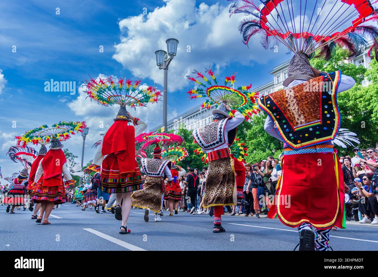 Berlin, Deutschland - 24. Mai 2026: Anden-Folklore-inspirierte Künstler mit kreisförmigen Federkopfschmuck tanzen während des Karnevals der Kulturen. Stockfoto