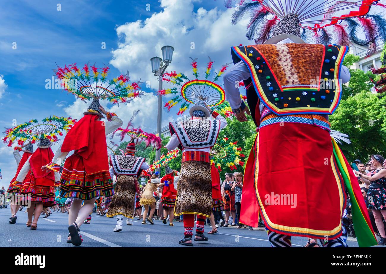 Berlin, Deutschland - 24. Mai 2026: Anden-Folklore-inspirierte Künstler mit kreisförmigen Federkopfschmuck tanzen während des Karnevals der Kulturen. Stockfoto