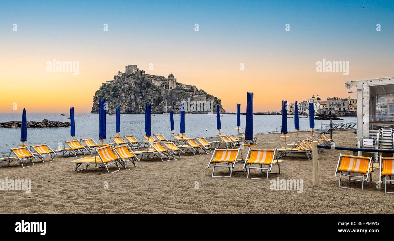 Dramatische Burg Aragonese und Damm vom Strand von Port Ischia aus gesehen, bei Sonnenuntergang in Ischia, Italien am 5. Mai 2026 Stockfoto