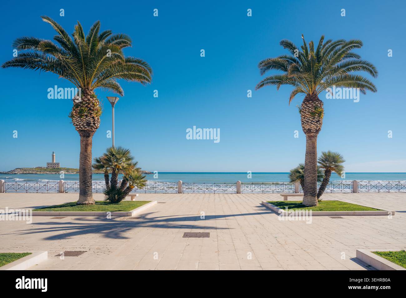 Malerischer Küstenweg in Vieste Italien mit Palmen mit Blick auf das Meer und den Leuchtturm Stockfoto