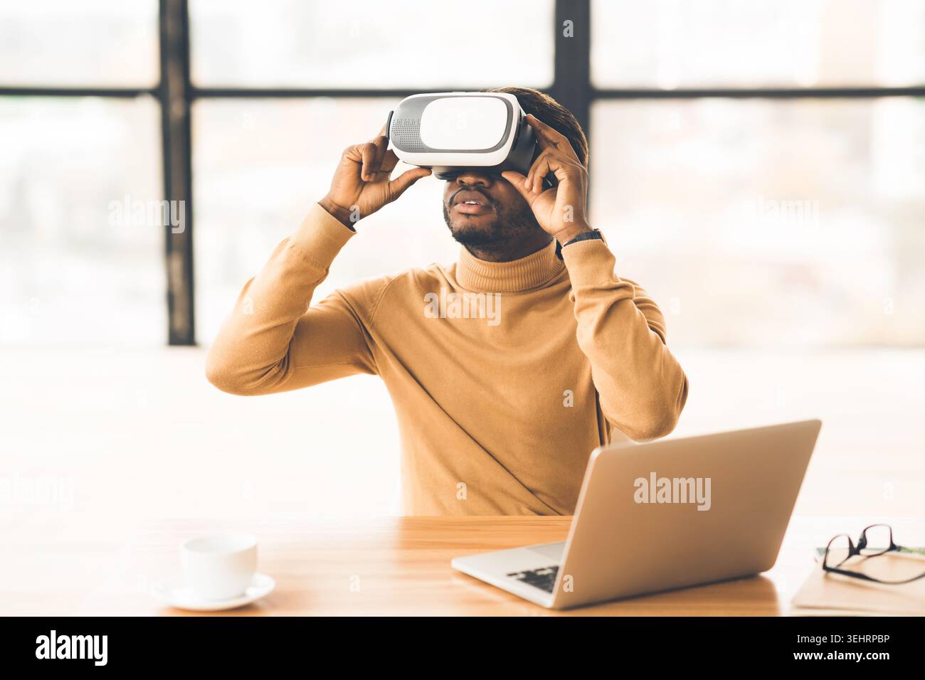 Afro-Geschäftsmann, der zu Hause eine Augmented-Reality-Brille trägt Stockfoto