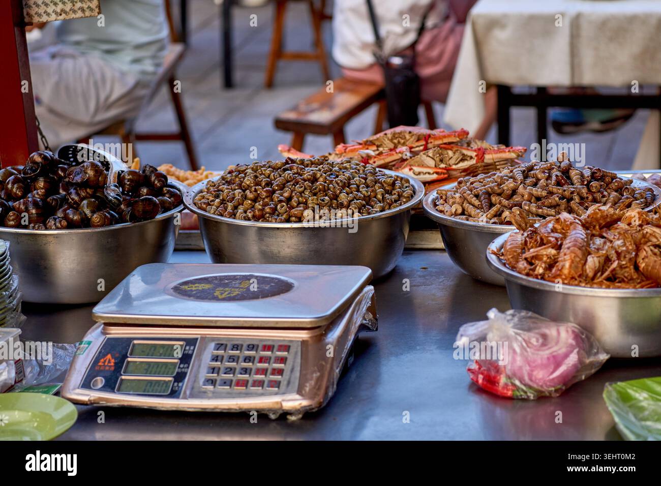 Nahaufnahme von Schnecken und anderen seltsamen chinesischen Speisen in einem Stand auf dem berühmten Drum Tower Nachtmarkt in der Innenstadt von Kaifeng, China Stockfoto