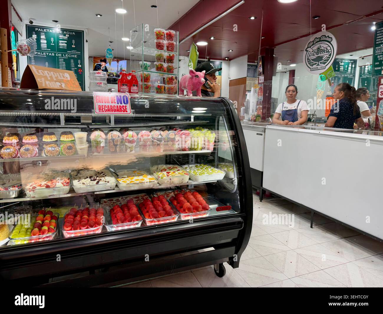 In einem traditionellen paletería in Coyoacán, Mexiko-Stadt, mit farbenfrohen Paletten, Eis und Obstdesserts zum Verkauf - Smartphone-aufgenommenes Stockfoto
