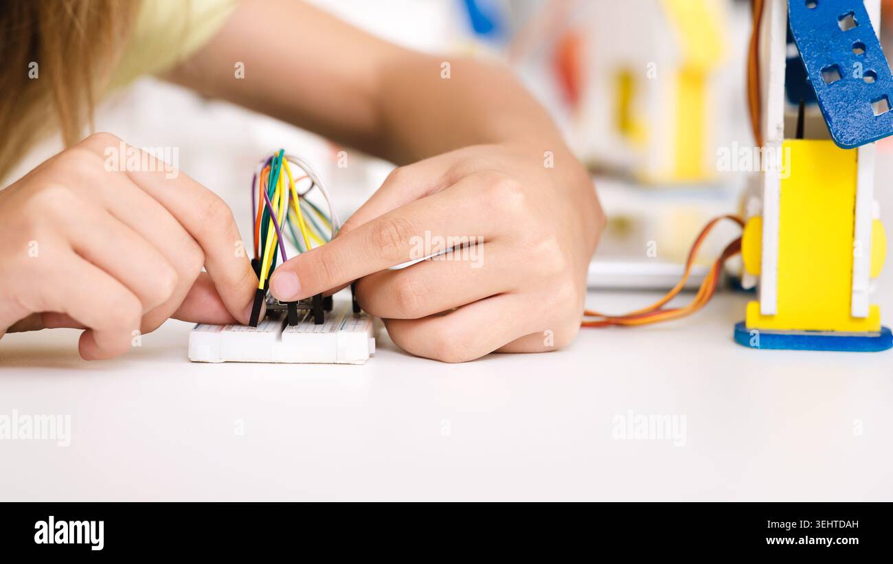 Hände, die tagsüber an der Verkabelung für ein Robotik-Projekt in einem Workshop arbeiten Stockfoto