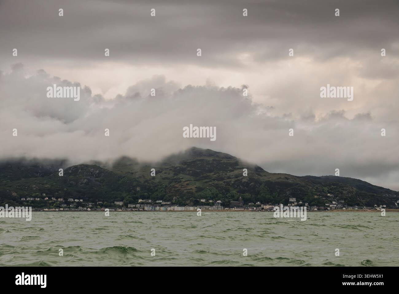 An einem nassen Tag in Nordwales hängt die niedrige Wolke über der Küstenstadt Barmouth, von außen gesehen vom Meer in der Cardigan Bay Stockfoto
