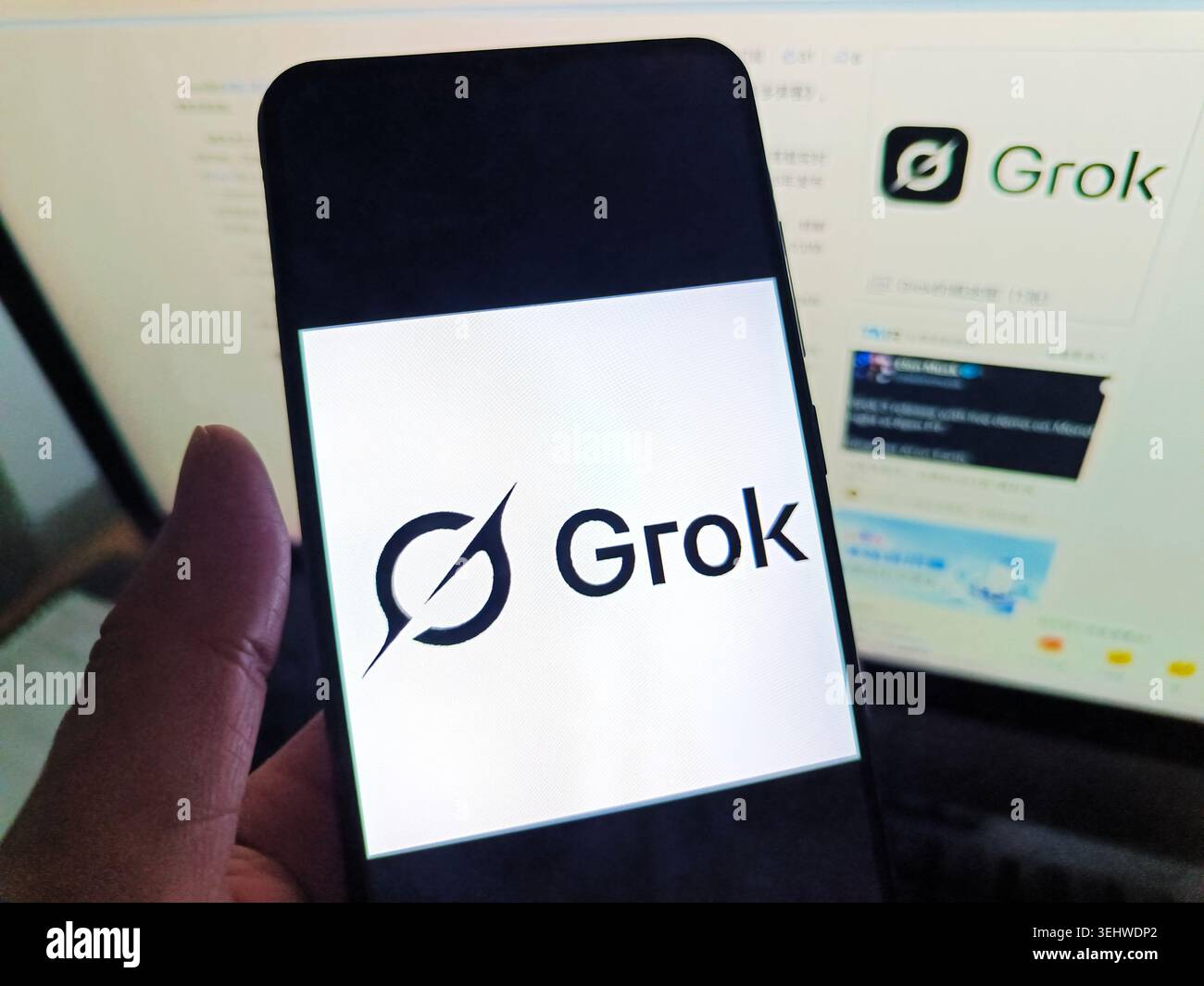 SUQIAN, CHINA - 26. MAI 2026 - Ein Netizen benutzt sein Handy, um das Grok-Logo zu sehen, und benutzt seinen Computer, um die Grok-Webseite in Suqian City, Provinz Jiangsu, China am 26. Mai 2026 anzusehen. Stockfoto
