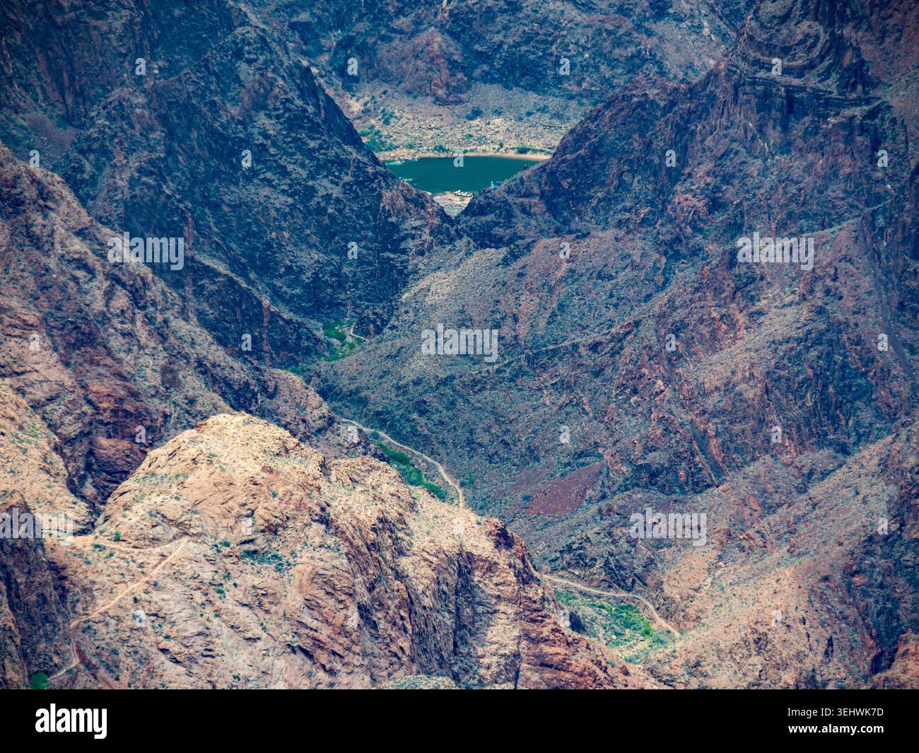Blick vom Südrand auf den Colorado River, mit Wanderwegen und einer kleinen Gruppe von Booten oder Kajaks, die auf dem Fluss sichtbar sind Stockfoto