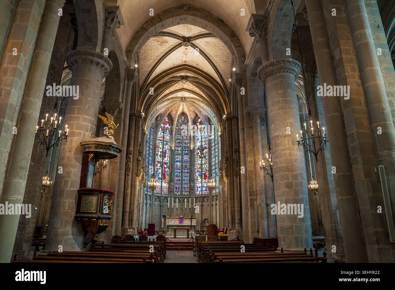 Im Inneren der Basilika befinden sich majestätische Schiffe mit Steinsäulen und gerippten Gewölben. Die Apsis wird von spektakulärem gotischen Buntglaswind beleuchtet Stockfoto
