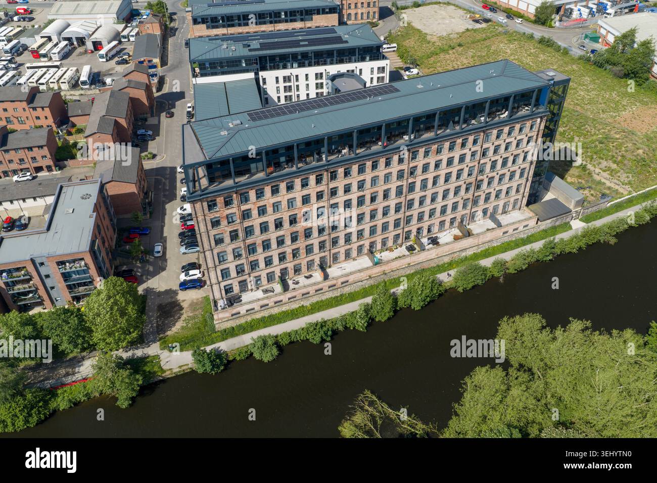 Drohnenansicht eines umgebauten Mühlenwohngebäudes neben dem Kanal in Leeds West Yorkshire, Großbritannien, mit moderner Wohnarchitektur und urbaner Architektur Stockfoto