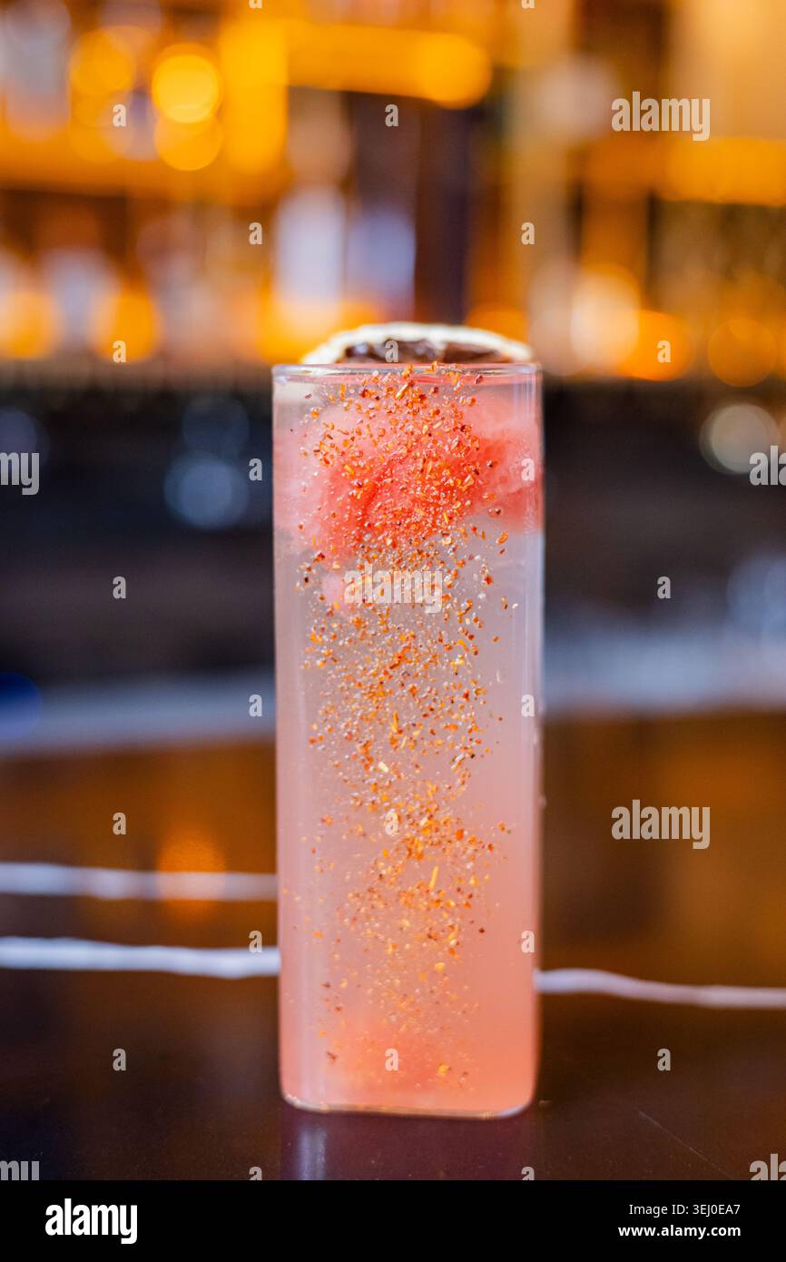 Ein erfrischender, farbenfroher Cocktail garniert mit Orangenschale und Eis Stockfoto