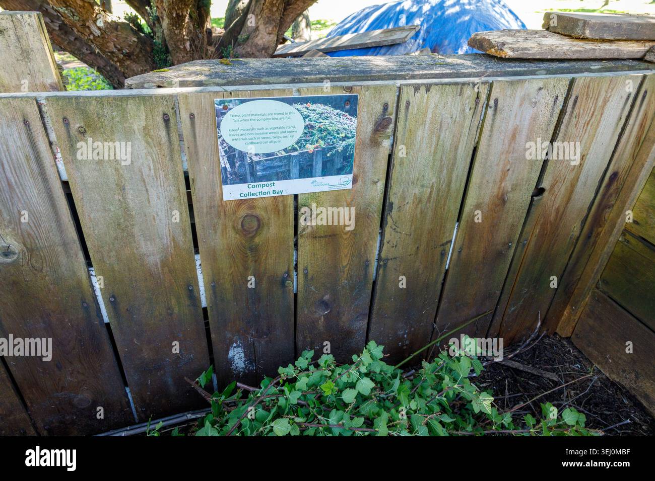 Vancouver, Kanada - 25. April 2026: Hölzerne gemeinschaftliche Kompost-Sammelbucht mit pädagogischem Schild, auf dem das hinzuzufügende Material erklärt wird, blaue Plane auf der Oberseite und Stockfoto