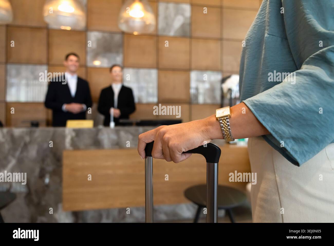 Weibliche Gäste, die mit Koffer an der Hotelrezeption ankommen, Nahaufnahme Stockfoto