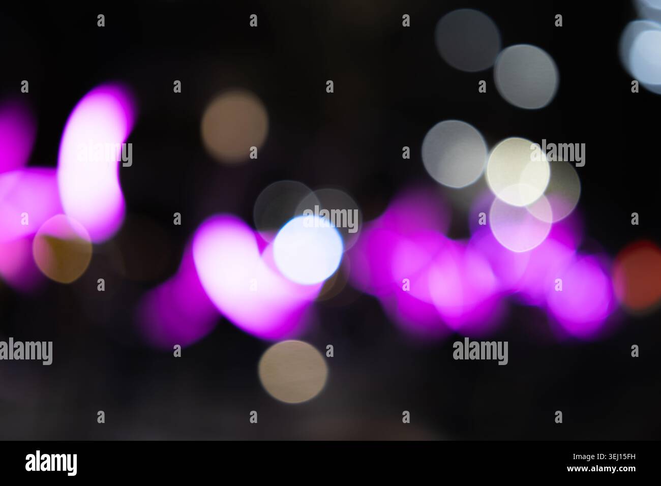 Unscharfe, violette Neonlichter leuchten in der Nacht Stockfoto