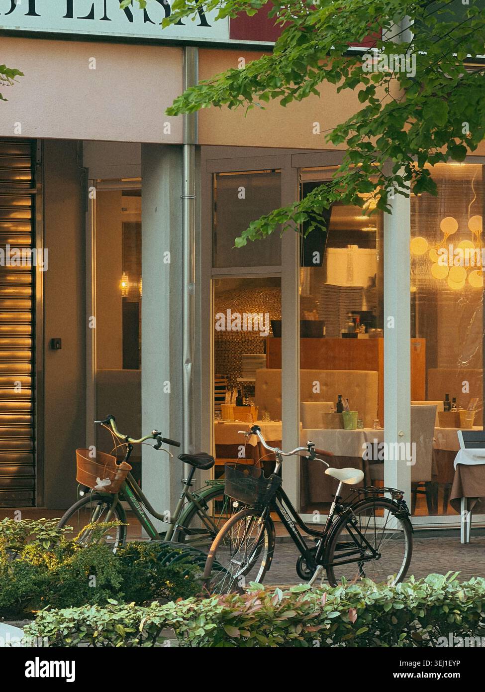 Fahrräder parkten abends vor einem gemütlichen Restaurant, Italien Stockfoto