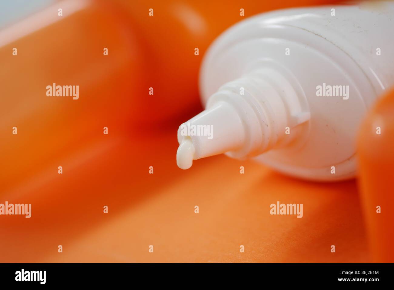 Nahaufnahme der Sonnencreme-Flasche auf orangem Hintergrund Stockfoto