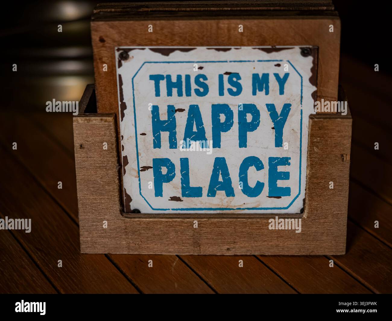 Das ist mein Happy Place hölzernes Schild, das auf einer dunklen Holztischoberfläche mit rustikalem blauem Schriftzug sitzt Stockfoto