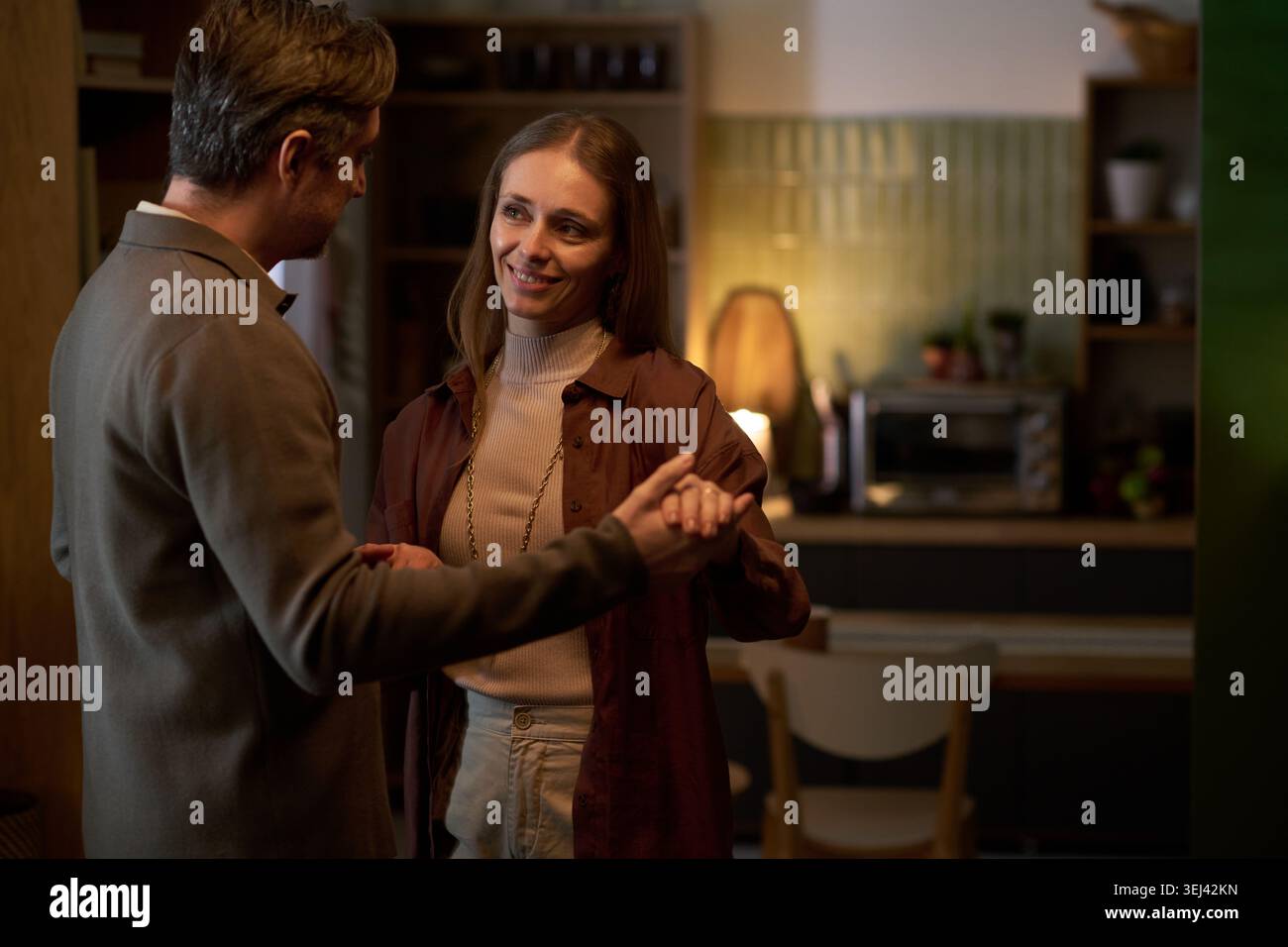 Erwachsenes Paar tanzt zu Hause während eines romantischen gemeinsamen Abends Stockfoto