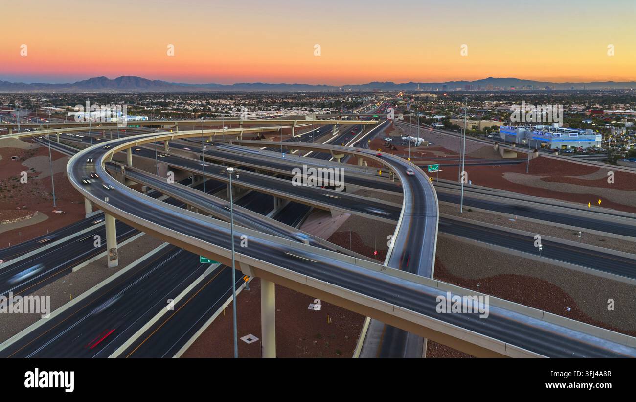 Aerial Las Vegas Highway Kreuzung bei Sonnenuntergang mit Blick auf die Stadt und die Berge Stockfoto