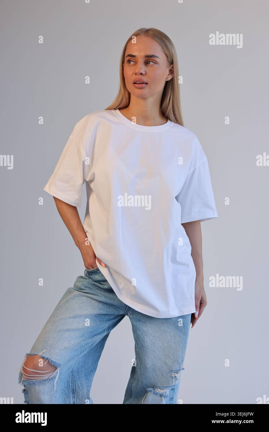 Ganzkörperaufnahme Einer Trendigen Frau Mit Gerissener Jeans Und Übergroßem Shirt In Der City Environment Stockfoto