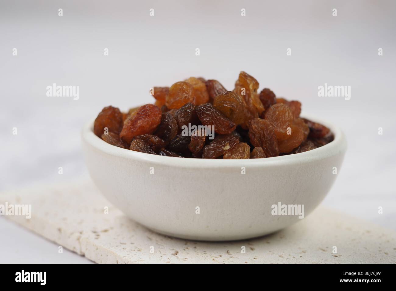 Verschiedene getrocknete Früchte in einer Schüssel auf einer hellen Oberfläche Stockfoto