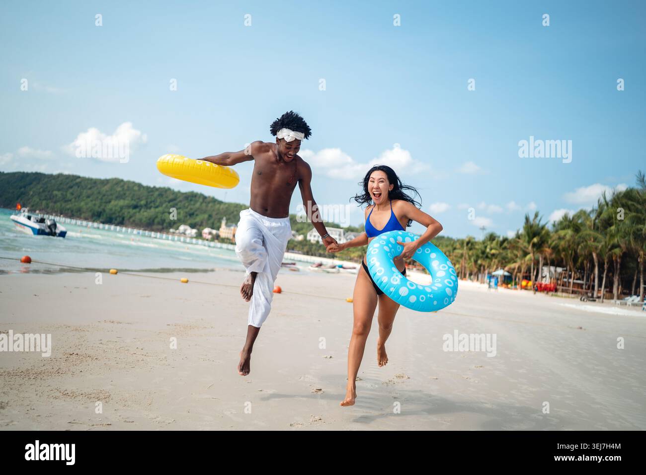 Reines Glück. Ein junges, vielseitiges, multiethnisches Paar genießt jeden Moment ihres tropischen Urlaubs Stockfoto
