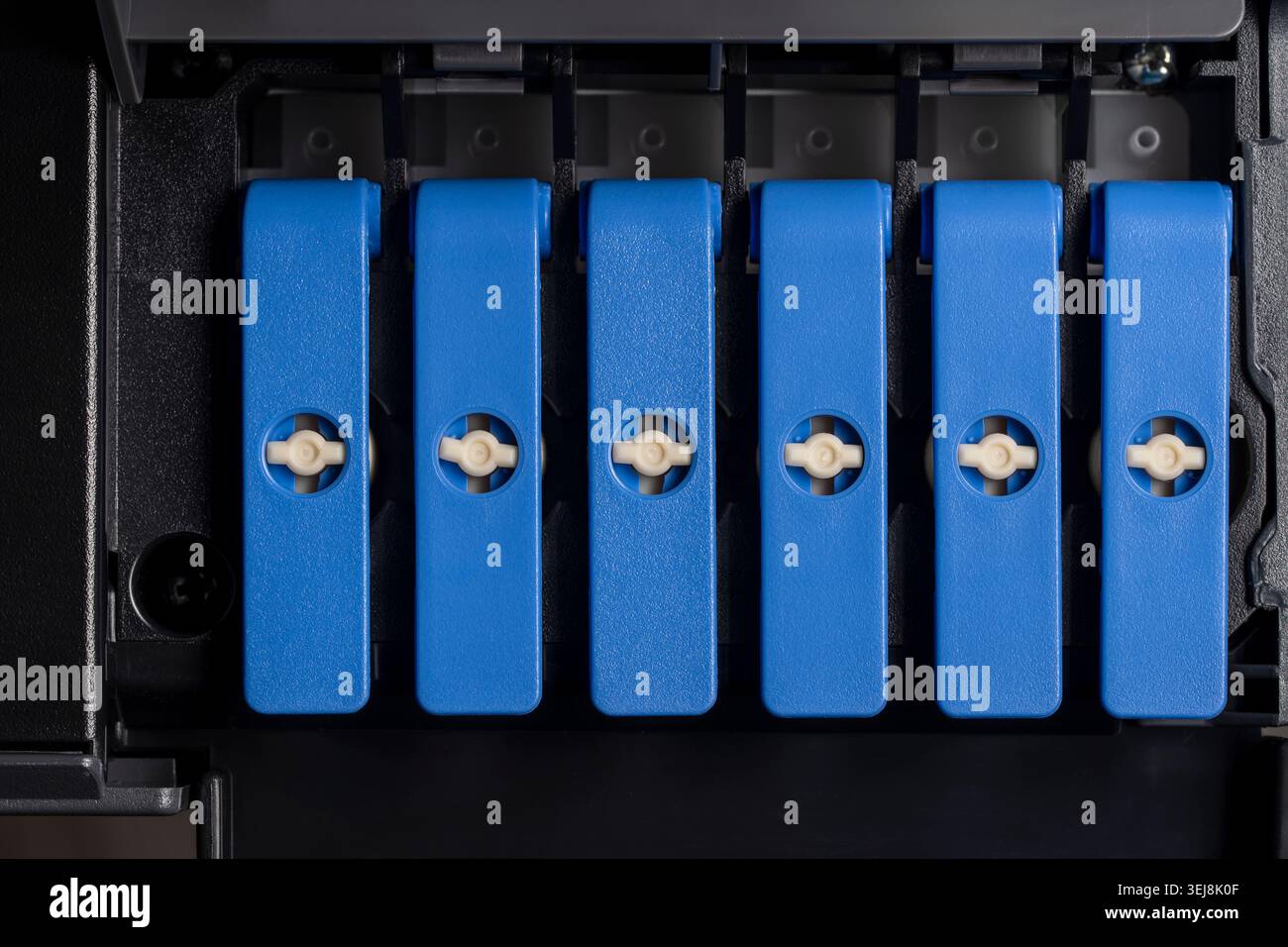 Nahaufnahme des Verriegelungsmechanismus der blauen Kunststoffhebel in einem Tintenstrahldrucker oder ciss-System. Konzept für das Instandhaltungsbüro equ für Computerhardware Stockfoto
