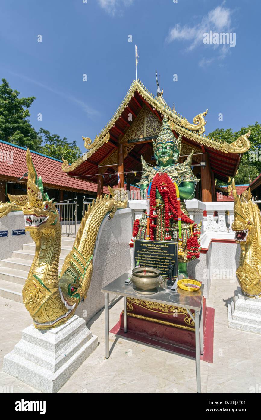 Dok Kham Tai, Phayao, Thailand - 28. Mai 2026: Wat Chaloem Phra Kiat (Wat San Pa Fang), Schutzfigur mit Opfertisch und Nagagelgeländer. Stockfoto