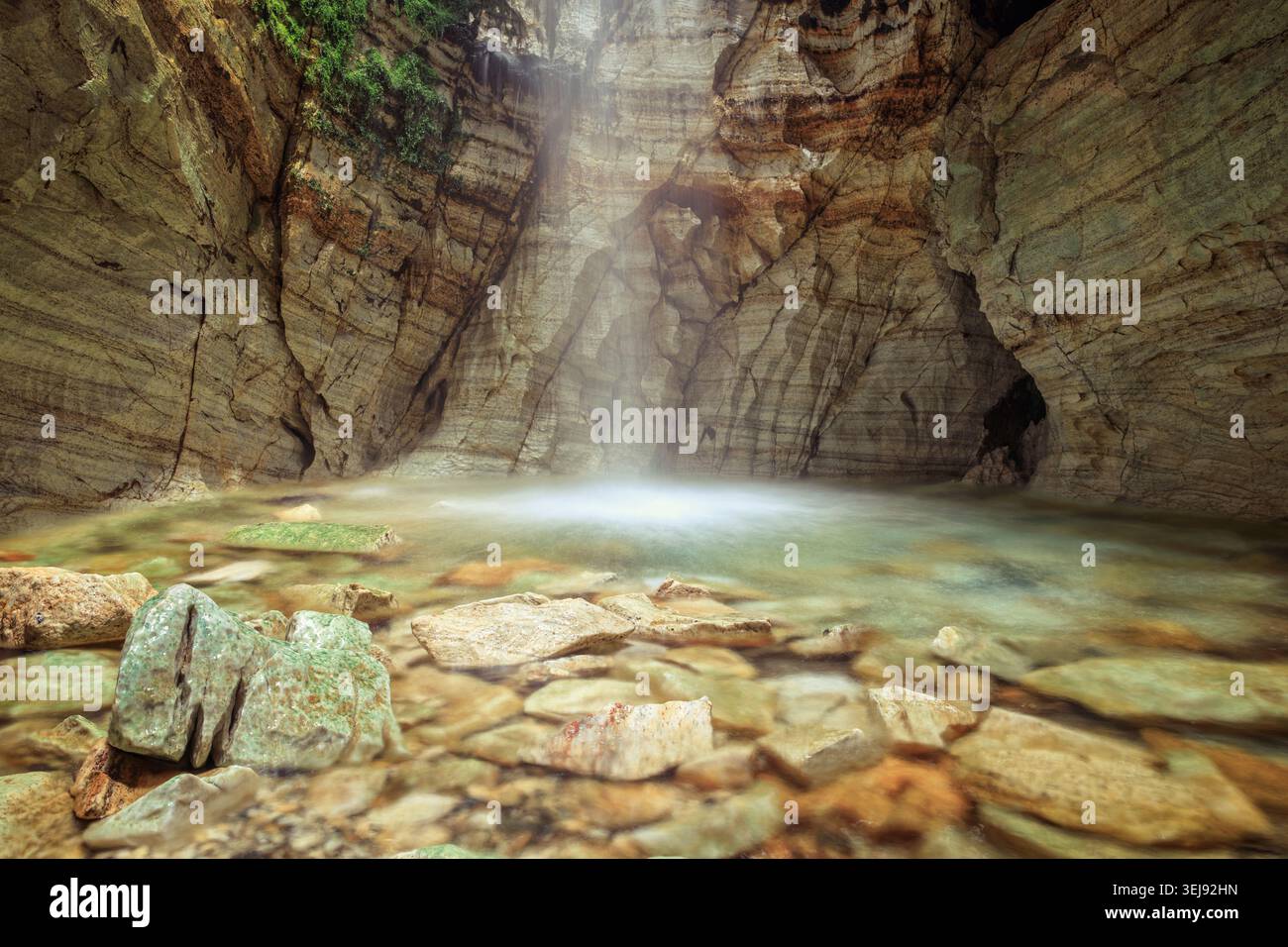 Trollkyrkja, Norwegen - 15.08.2023: Atemberaubender unterirdischer Wasserfall fällt in einen kristallklaren Pool in einer Marmorhöhle. Stockfoto