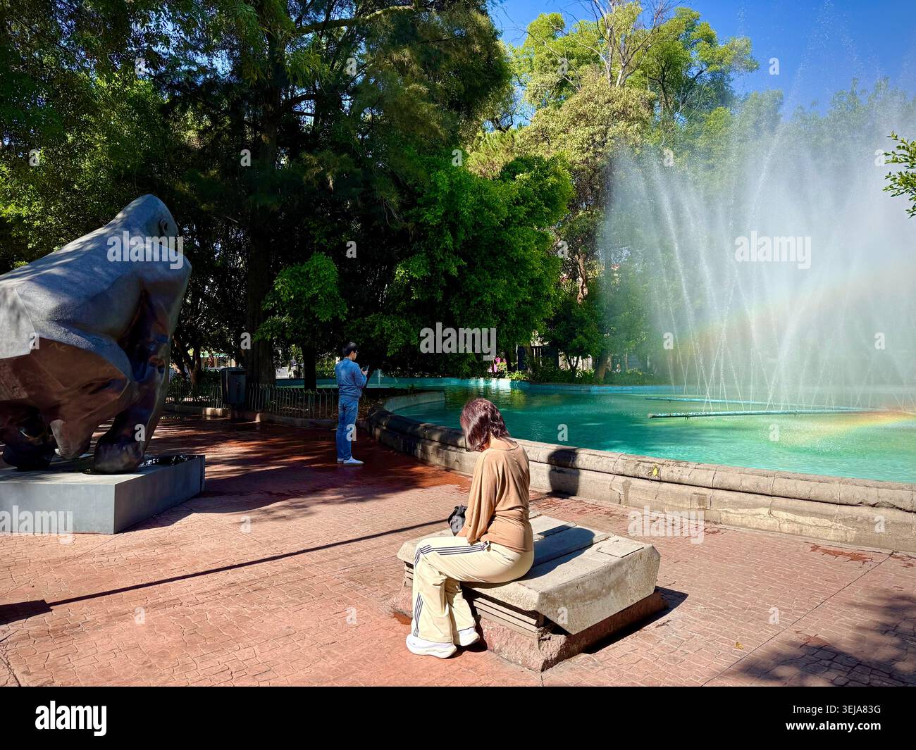 Menschen neben einer großen öffentlichen Skulptur neben dem Brunnen auf der Plaza Luis Cabrera, einem grünen Platz in Roma Norte, Mexiko-Stadt Stockfoto