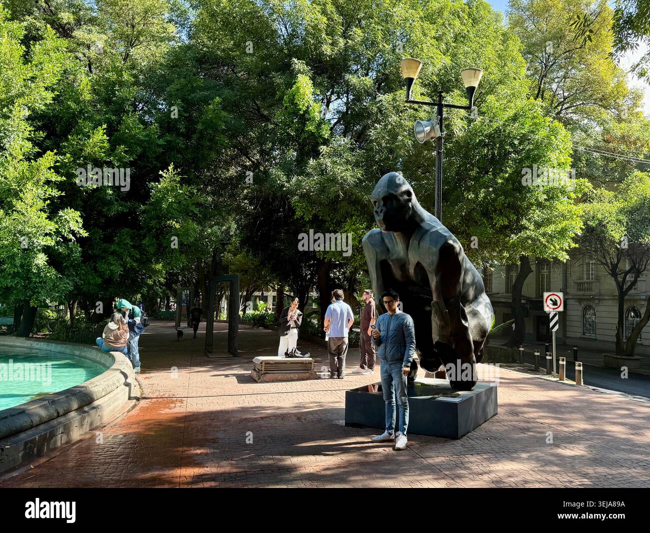 Menschen neben einer großen öffentlichen Skulptur neben dem Brunnen auf der Plaza Luis Cabrera, einem grünen Platz in Roma Norte, Mexiko-Stadt Stockfoto