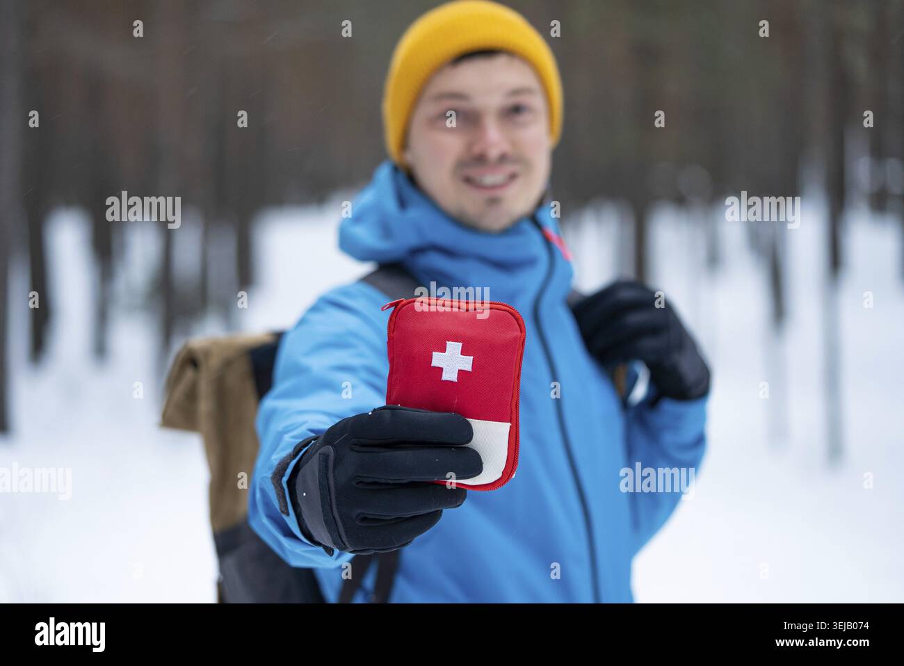 Mann zeigt roten erste-Hilfe-Kasten bei Winterwanderung Stockfoto