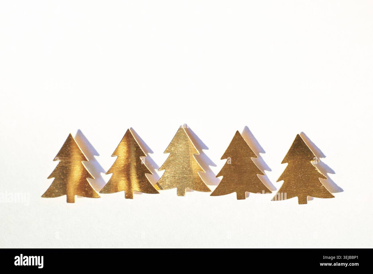 Fünf Goldene Weihnachtsbaum-Silhouetten Auf Weißem Hintergrund Für Festliche Dekoration Und Weihnachtsthemen Stockfoto