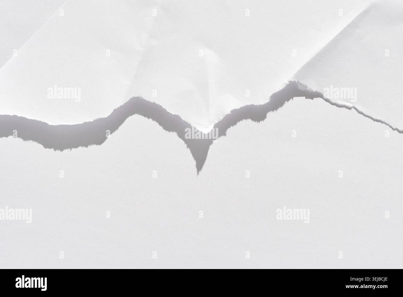 Nahaufnahme von gerissenem weißem Papier mit gezackten Kanten und einzigartiger Textur, die eine Trennlinie zeigt Stockfoto