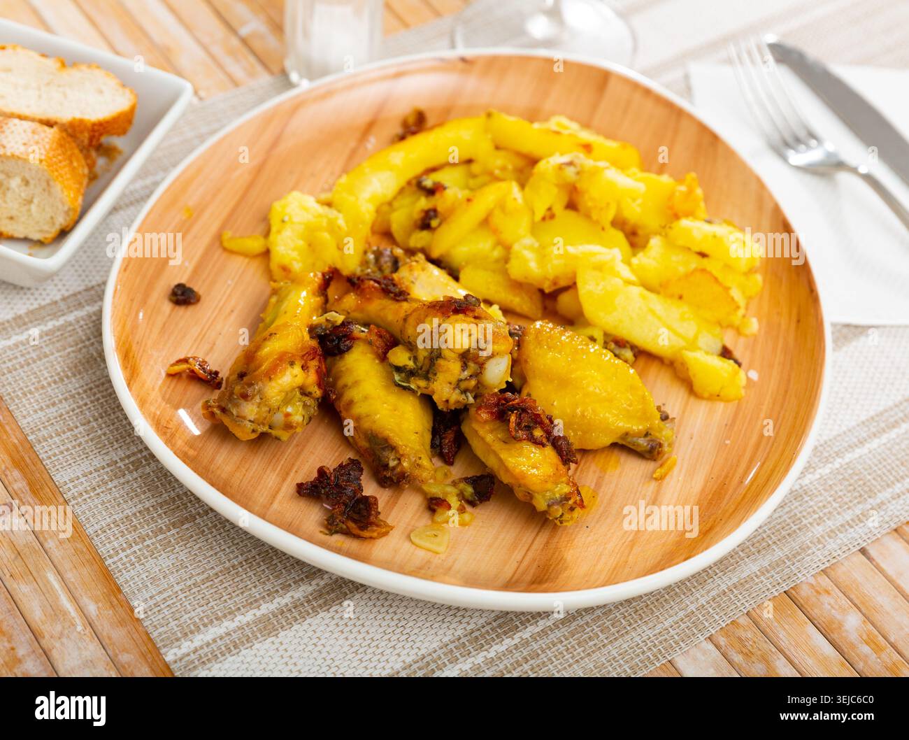 Knoblauch-Hühnerflügel (Pollo al Ajillo) mit Kartoffeln. Stockfoto