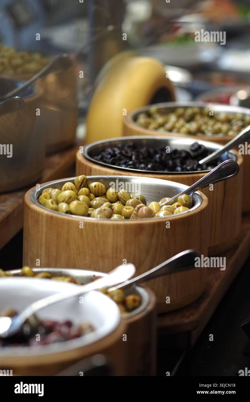 Schüsseln mit Speisen auf einem Holztisch am Buffet Stockfoto