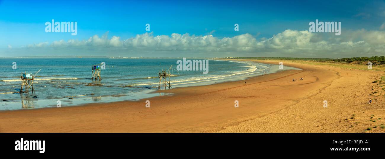 Aveiro, Portugal - 19.08.2023: Küstenlandschaft mit traditionellen Netzfischern in flachen Atlantikwellen an einem weiten sonnigen Strand Stockfoto