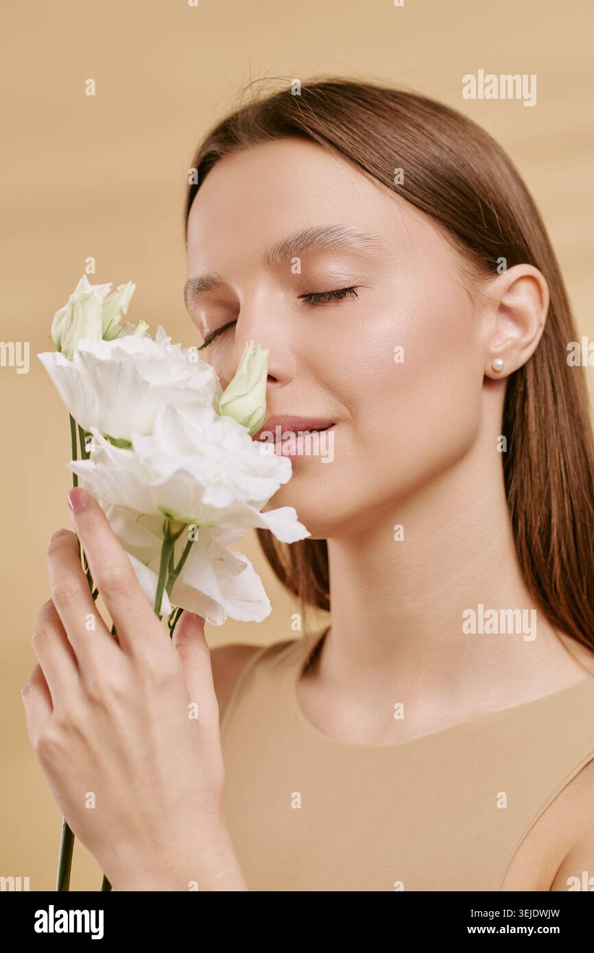 Erwachsene Frau riecht Blumen für Beauty Wellness Branding Stockfoto