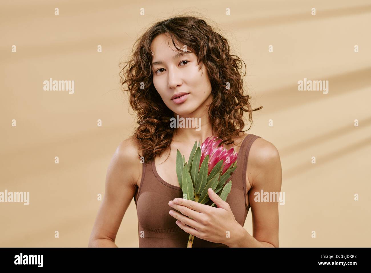 Porträt einer asiatischen erwachsenen Frau, die Blume für Beauty Branding hält Stockfoto